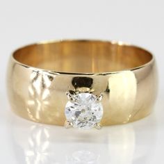 a yellow gold wedding ring with a single diamond