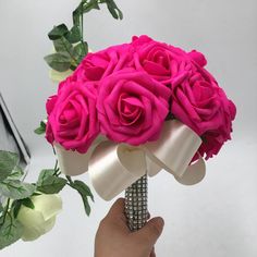 a person holding a bouquet of pink roses