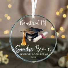 a glass ornament with a graduation cap and tassel