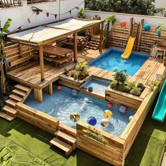 an above ground swimming pool with slide in the middle and wooden decking around it