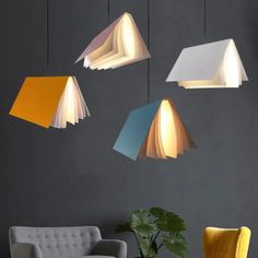 four different colored lamps hanging from the ceiling above a couch and chair in a living room