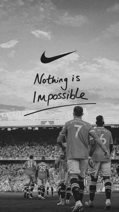 two soccer players walking on the field with their backs to each other, and an ad that reads nothing is impossible