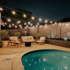 an outdoor patio with lights strung over the pool and seating area next to the swimming pool