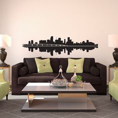 a living room with couches, chairs and a coffee table in front of a city skyline wall decal