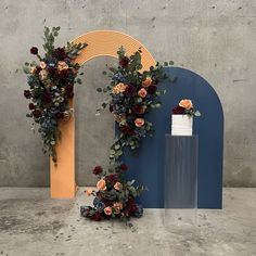 two vases with flowers on them next to a decorative arch in the shape of a heart