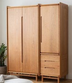 a large wooden cabinet sitting next to a plant in a living room with white walls