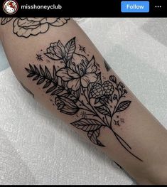 a black and white flower tattoo on the arm