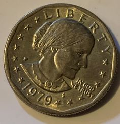 a close up of a coin with a woman's head on it and stars in the background