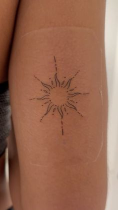 a woman's leg with a tattoo on it that has a sun in the middle