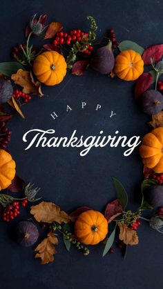 a thanksgiving wreath with pumpkins and leaves around it on a dark background that says happy thanksgiving