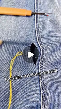 a pair of scissors is cutting through the hole in a jeans pocket with yellow thread