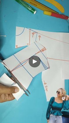 a woman is cutting out some paper with scissors