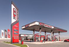 a red and white gas station with cars parked at it's pump pumps in the background