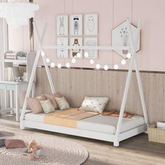 a child's bedroom with pink walls and white bed frame, wooden flooring