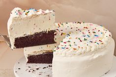 a cake with white frosting and sprinkles is cut from the plate