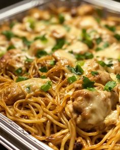 a pan filled with spaghetti and meat covered in sauce