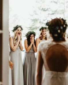 the bridesmaids are laughing as they stand in front of the mirror and look at each other