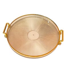 a gold serving tray with handles is shown on a white background, it has a circular design in the center