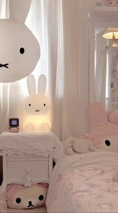 a bedroom with white walls and pink bedding is decorated in pastel colors, including bunny ears