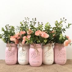 four pink mason jars with flowers in them