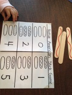 a young child is playing with some sort of number matching game on the table in front of them