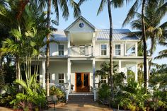 a large white house surrounded by palm trees