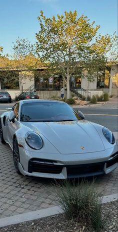 a white sports car parked on the side of the road