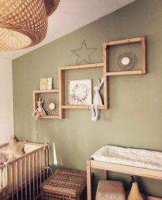 a baby's room with green walls and pictures on the wall, including a crib