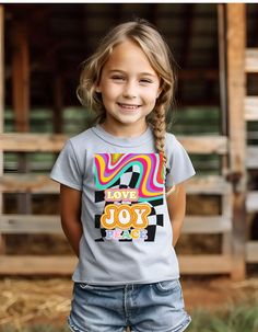 The kids heavy cotton tee is perfect for everyday use. The fabric is 100% cotton for solid colors. Polyester is included for heather-color variants. These fabrics are prime materials for printing. The shoulders have twill tape for improved durability. The collar is curl resistant due to ribbed knitting. There are no seams along the sides.  .: Made with 100%, midweight (5.3 oz/yd² (180 g/m US cotton that feels soft to the touch and a great choice for any season. .: The crew neckline along with th Cotton T-shirt With Name Print For Daycare, Playful T-shirt For Daycare, Short Sleeve T-shirt For Daycare, Casual Text Print T-shirt For Daycare, Playful Crew Neck T-shirt For Daycare, Fun Crew Neck T-shirt, Crew Neck T-shirt With Letter Print For Daycare, Cotton T-shirt With Letter Print For Playtime, Playful Graphic Print T-shirt