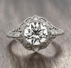 an old - fashioned diamond ring is shown on a wooden surface with diamonds around it