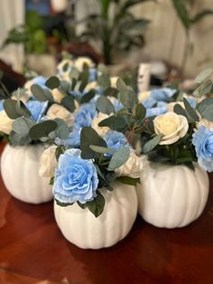 small white pumpkins with blue flowers in them