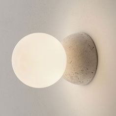 a light that is on the wall next to a white object with a round hole in it