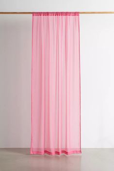 a pink curtain hanging on the side of a wall