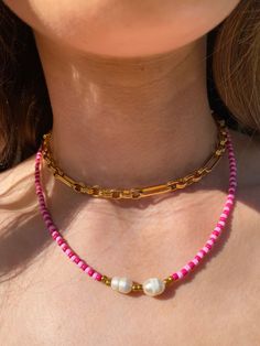 a woman wearing a pink and gold necklace