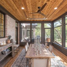 a dining room with wooden ceiling and large windows