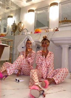 two women sitting on the floor in matching pajamas