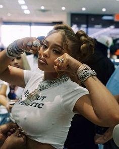 a woman in a white shirt and some bracelets