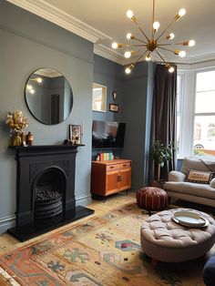 a living room filled with furniture and a fire place in front of a mirror on the wall