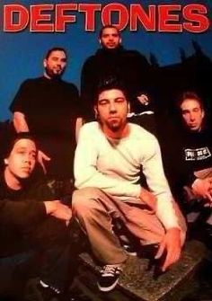 a group of men sitting next to each other in front of a blue background with the words deftones on it