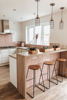 three stools sit at the center of a kitchen island