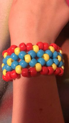 a close up of a person's hand wearing a bracelet with beads on it