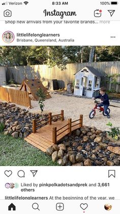 a kid riding a bike on top of a wooden bridge next to a small house