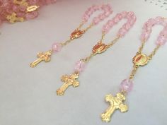 "20 Rosarios pequeñitos o decenario en color rosa., hechos a Mano con la Imagen de la virgen de Guadalupe , bañados en Oro y hechos de acrilico con figurita de rosa. Mide cerca de 10cm de largo y Las cuentitas importados son de 6 mm. 20 PINK COLOR , ACRYLIC BEADS IN SHAPE OF ROSEBUDS ON THIS MINI ROSARIES . ALL HAND MADE AND GOLD PLATED THEY MEASURE ABOUT 4\" INCHES EACH. COMVO US WITH Any QUESTIONS. Thanks!" Pink Beaded Jewelry For Baptism, Pink Spiritual Jewelry For First Communion, Pink Cross Rosary Bracelet Gift, Pink Cross-shaped Rosary Bracelet Gift, Handmade Pink Rosary For Baptism, Pink Rosary For First Communion, Pink Rosary With Round Beads For First Communion, Handmade Pink Rosary For First Communion, Handmade Pink Jewelry For Baptism