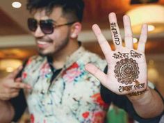 a man is holding his hand up to show the hendi design on his palm