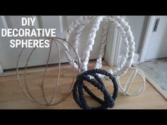 three circular objects sitting on top of a wooden floor next to a door with the words diy decorative spheres