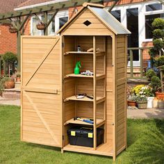 a wooden shed with its door open and shelves on the outside, in front of a house