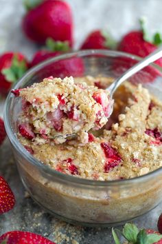 a bowl filled with oatmeal and strawberries on top of a table