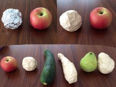 several different types of fruits and vegetables on a wooden cutting board, including apples, pears, cucumbers, and more