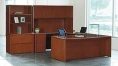 an office desk and bookcases in front of large windows with glass doors on each side