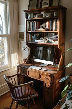 a wooden desk with a computer on top of it next to a chair and window